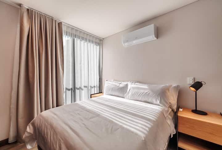Elegante dormitorio doble con aire acondicionado, grandes ventanales con hermosas vistas, mucha luz natural y TV. Amplio y elegante, perfecto para relajarse con comodidad.