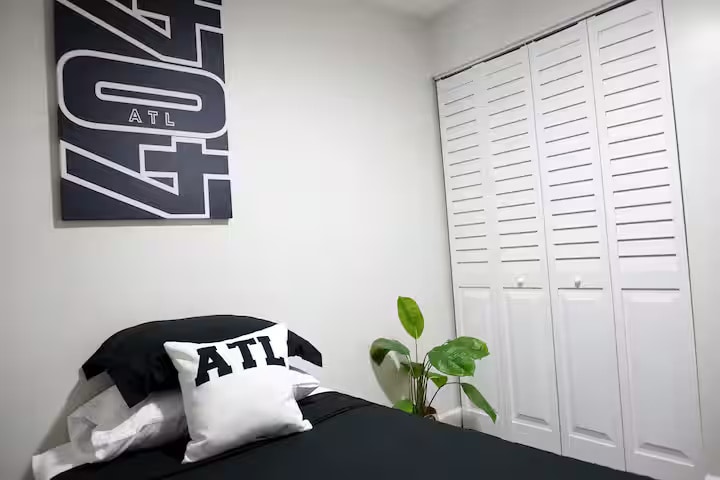 פינת חדר שינה נקייה עם יצירות אמנות מקומיות נועזות, מצעים רכים ועיצוב פשוט. מקום נוח לנוח בו, עם גישה לארון בקרבת מקום לשהיות קלות.
