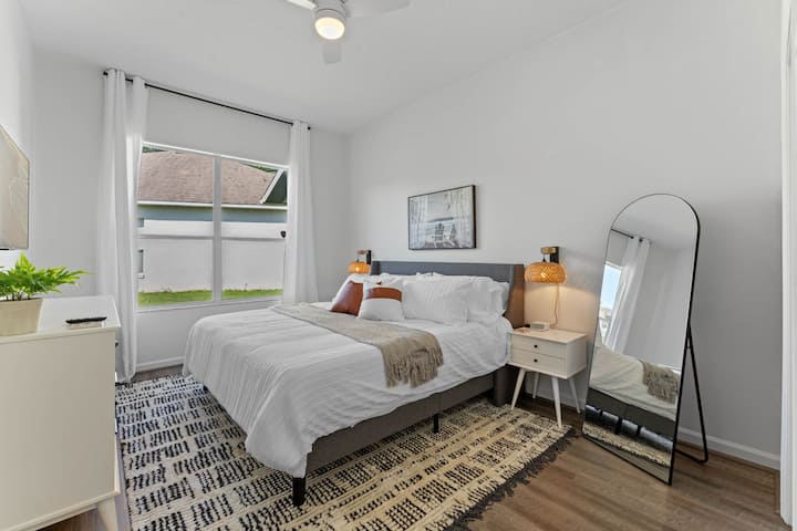 Dormitorio tamaño king completo con TV y un cómodo colchón.