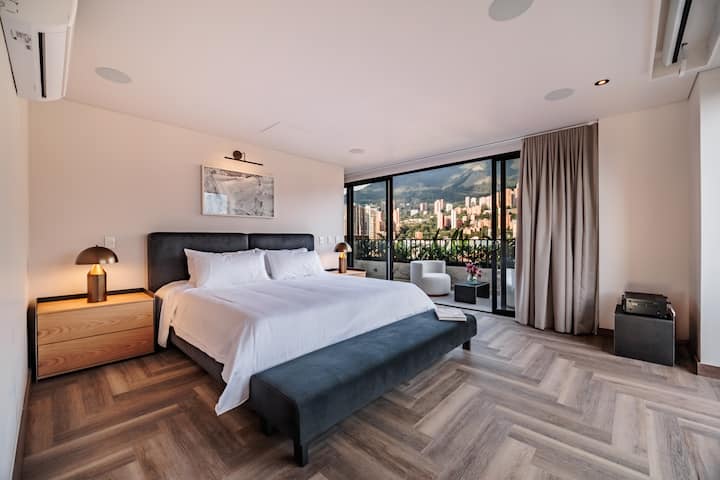 Modern master bedroom featuring a king-size bed, closet, and balcony. Sunlit and inviting, ideal for a restful night and enjoying the fresh air from your private balcony.