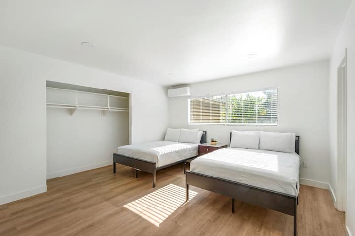 غرفة نوم مريحة مع سريرين كاملين وتصميم بسيط وجيد التهوية - مثالية للعائلات أو المجموعات.