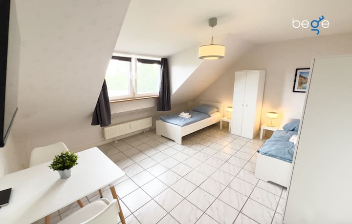 غرفة نوم 4 مع سريرين مفردين ومنطقة جلوس وتلفزيون ذكي 