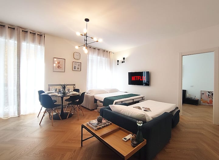 Pohľad na obývaciu izbu s prístupom na veľký balkón, tentoraz s rozloženými rozkladacími pohovkami pripravenými na noc. Praktický priestor pre maximálne 5 hostí.
Dve oblasti určené na odpočinok majú 50-palcovú inteligentnú TV