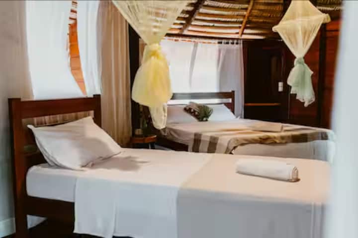 Quarto confortável com cama ampla, mosquiteiro e iluminação natural
