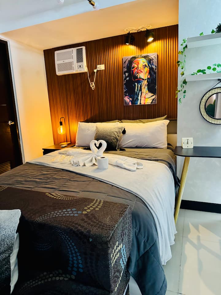 Útulné moderné štúdio vo Viceroy Residences Tower 3 s pohodlnou posteľou, teplým osvetlením, drevenou stenu a vybavením v hotelovom štýle – ideálne na pobyt v blízkosti nákupného centra Venice Grand Canal Mall.