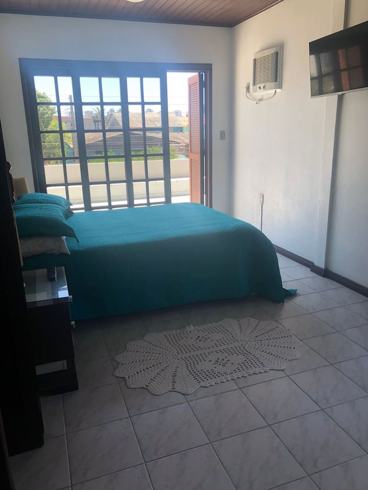 Dormitorio con mesita de noche, vestidor, TV, aire acondicionado. 