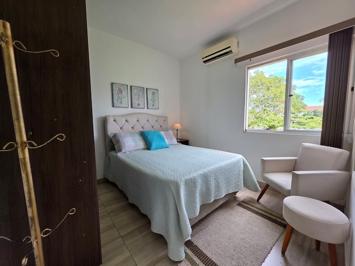 Chambre 1 équipée d'un lit double, de la climatisation, de rideaux occultants, de draps et d'un espace de rangement pour les vêtements.