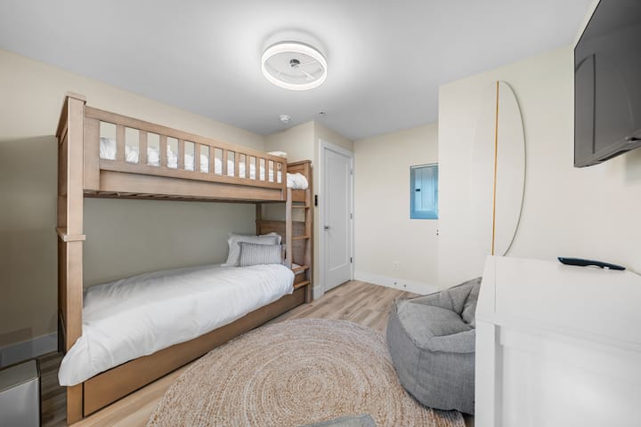 غرفة نوم بطابقين مصممة للاسترخاء وليالي مشاهدة الأفلام والقيلولة على الشاطئ - كاملة مع كراسي مريحة على شكل كيس من الفاصوليا وأروقة.