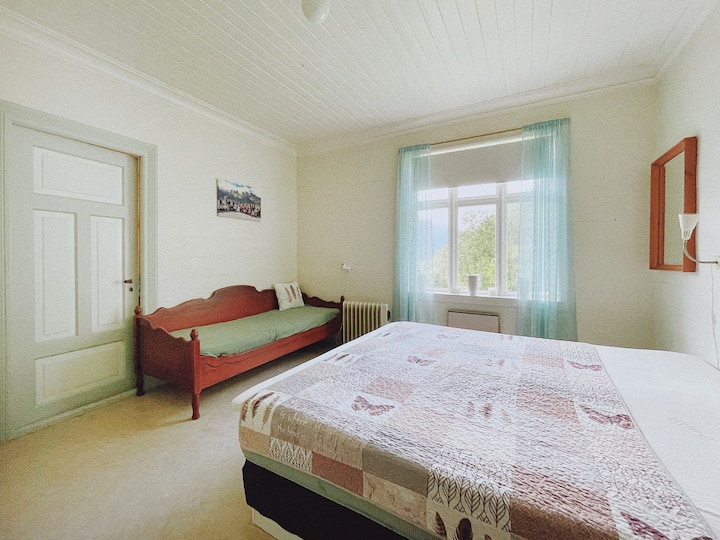 חדר שינה שני מרווח עם מיטה זוגית ופינת ישיבה נוספת.