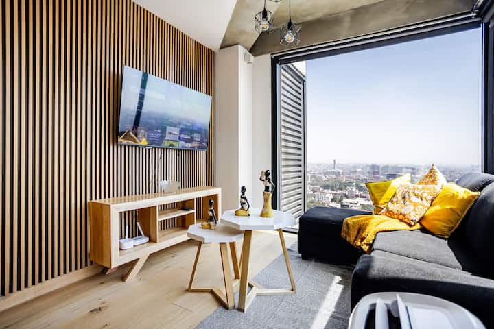 Sala con ventanales de piso a techo y espectacular vista panorámica de CDMX desde el piso 24, ubicada en plena zona Reforma.