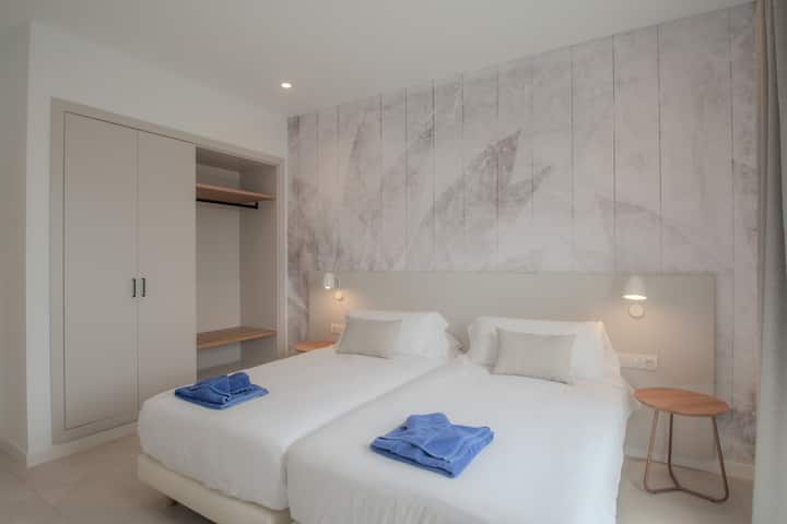 Dormitorio con baño privado y vistas hacia el jardín 