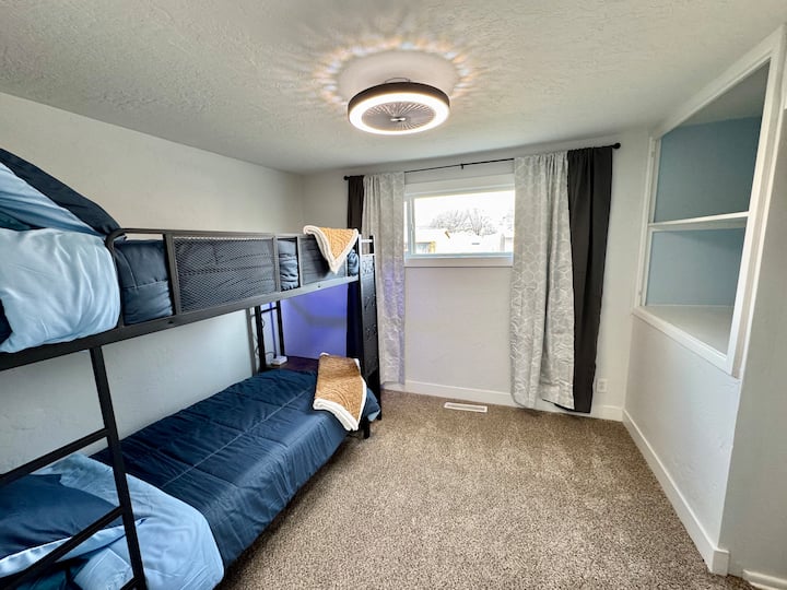 ორი ერთადგილიანი საწოლისგან შემდგარი ორადგილიანი ოთახი, რომელშიც ფარდები გაშლილია 