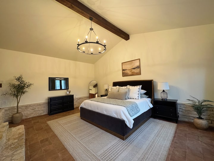 Tágas fő hálószoba puha king méretű ággyal, boltíves mennyezettel, fagerendával és elegáns világítással. Átgondoltan berendezett, nyugodt légkörrel, bőséges tárolóhellyel és pihentető éjszakákkal.