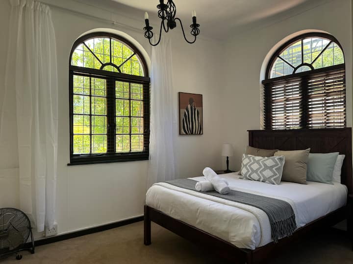 The spacious second bedroom offers ample natural light and an en-suite bathroom
