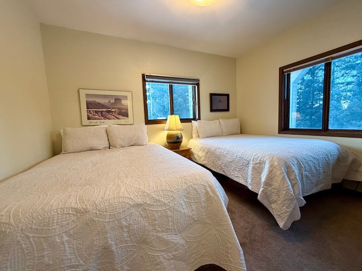 The guest bedroom offers a restful retreat, featuring two queen-size beds with soft, comfortable bedding to create a calm and cozy space perfect for unwinding and enjoying a peaceful night’s rest.
