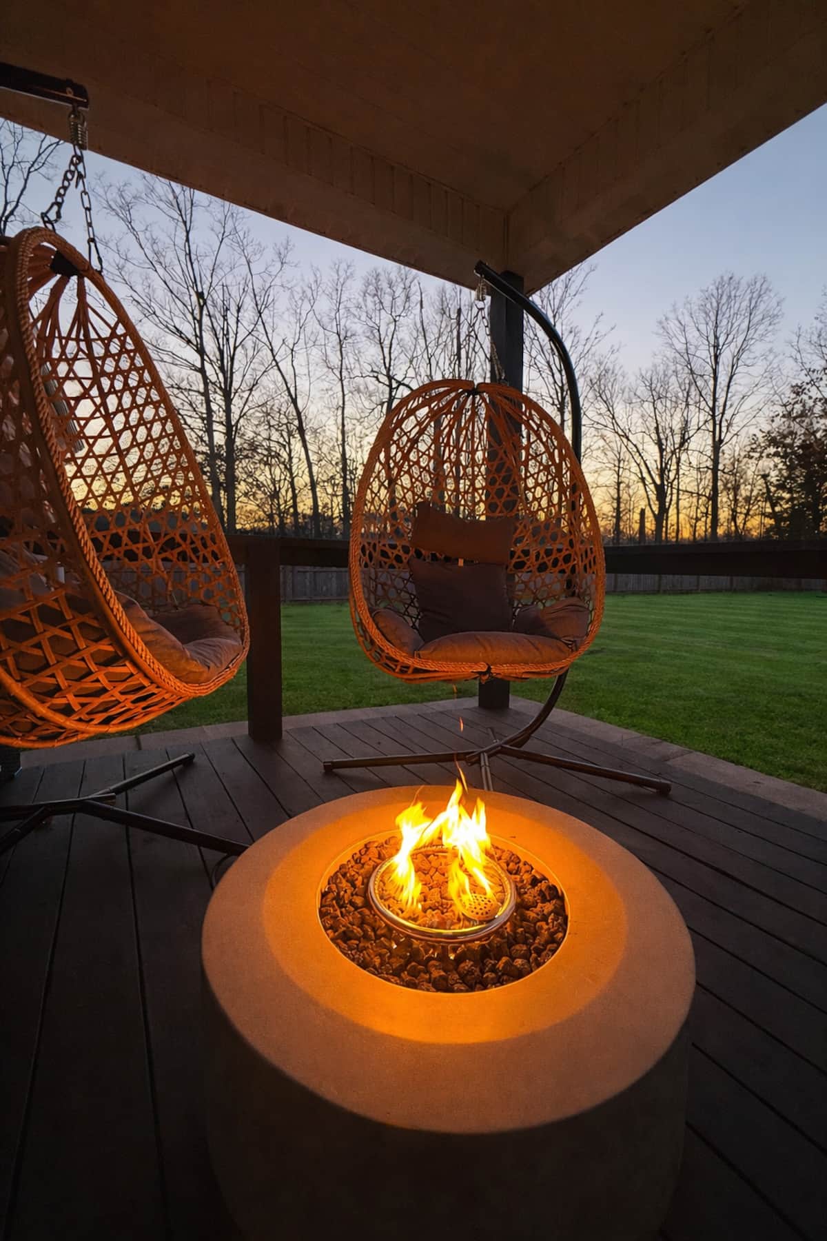 Covered porch with hanging lounge chairs at sunset