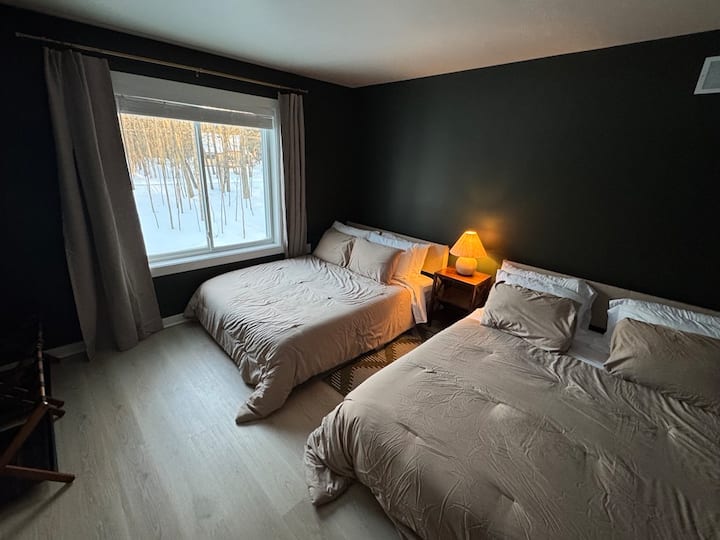 تحتوي غرفة النوم رقم 3 على سريرين مريحين بحجم كوين مع ستائر. إطلالات رائعة على الأشجار ومقدمة عقار الشاليه!