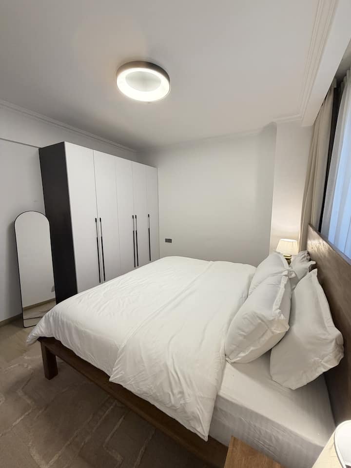 A bright and inviting second bedroom featuring a comfortable queen-size bed, soft linens and a serene atmosphere for a restful and relaxing stay.