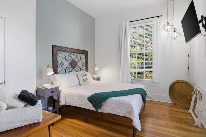 Suíte Garden com cama queen size, ao lado da cozinha, com Smart TV, cortinas blackout e suporte para bagagens.