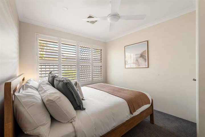 Pumzika katika chumba cha pili cha kulala kilicho na kitanda aina ya king na sauti za kutuliza ambazo zinakaribisha usiku wa kupumzika baada ya siku kando ya ghuba.