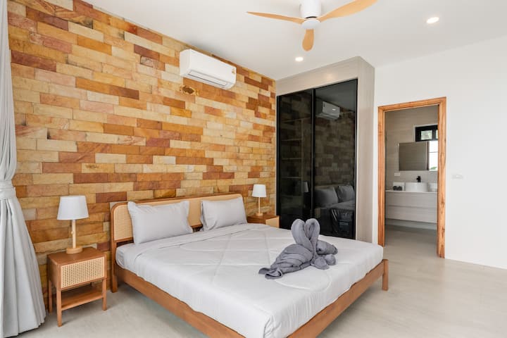 Chumba cha kulala chenye starehe chenye muundo wa kisasa wa kitropiki na sanaa ya taulo katika Sunrise Hill Villa Thailand