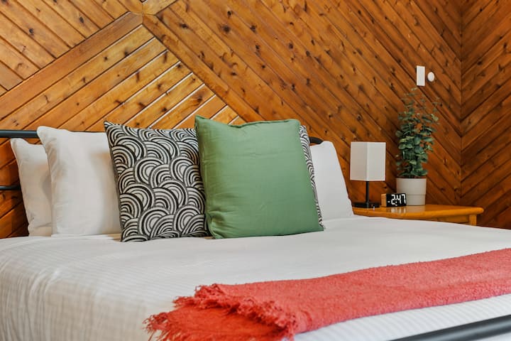 Cuarto dormitorio, ubicado en el piso principal, con una cama tamaño king, persianas opacas, tocador y patio con acceso directo al patio trasero.