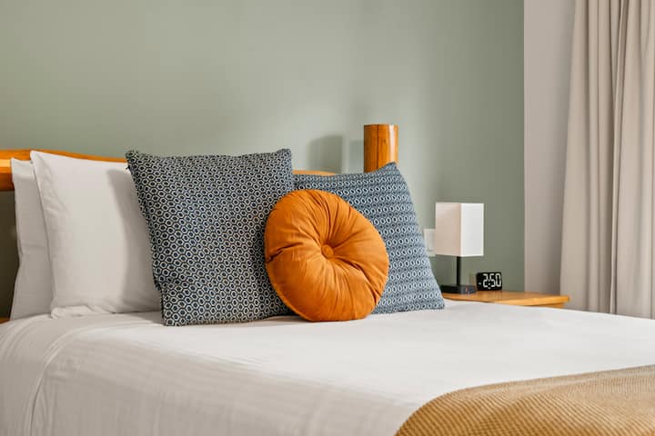 Dormitorio principal en el piso superior con cama tamaño queen, vestidor, cortinas opacas, acceso al patio exterior y baño privado.