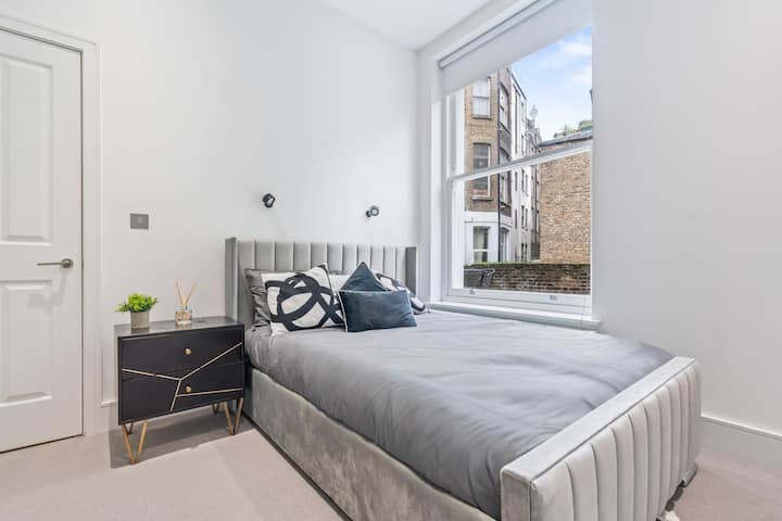 חדר שינה שני - חדר שינה שקט ומודרני עם מיטה מרופדת נוחה, מצעים נקיים, יצירות אמנות אופנתיות ואור טבעי לשינה שלווה.