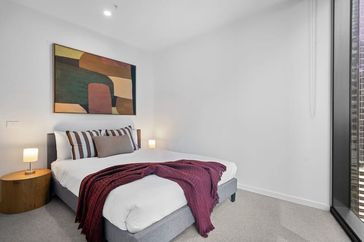 Une chambre principale avec un lit queen size et des oreillers moelleux.