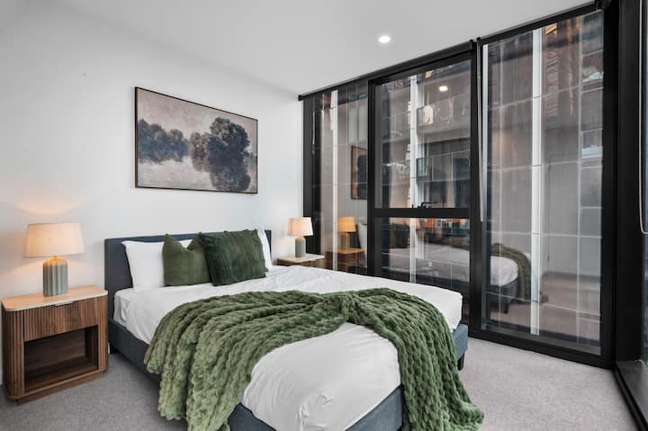 Une chambre principale avec un lit queen size et des oreillers moelleux.