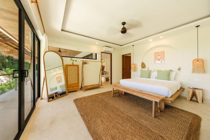 Master bedroom with king-size bed, large sliding door (balcony access), ample natural light, and a calm, restful atmosphere perfect for recharging in Amed, Bali.