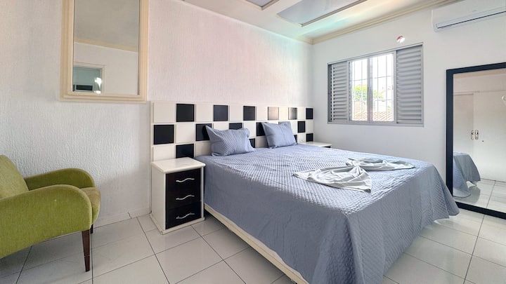 Quarto com ar-condicionado, cama king com roupas de cama e travesseiros inclusos.