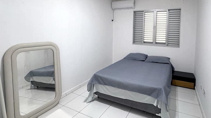 Quarto com ar-condicionado,  cama de casal com roupas de cama e travesseiros inclusos.
