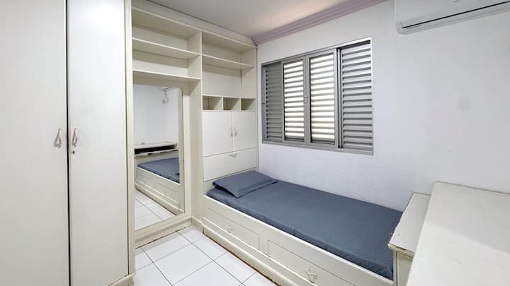 Quarto com ar-condicionado,  cama de solteiro com roupas de cama e travesseiros inclusos.