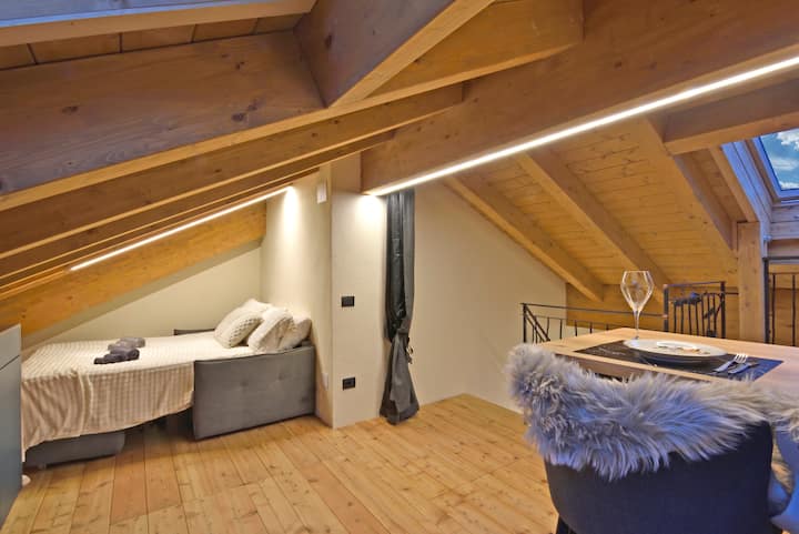 ห้องนอนที่สองสวยงามพร้อมเตียงโซฟาคิงไซส์ ผ้าเช็ดตัวครบชุด และหน้าต่างที่มีวิวท้องฟ้าที่น่าตื่นตาตื่นใจ