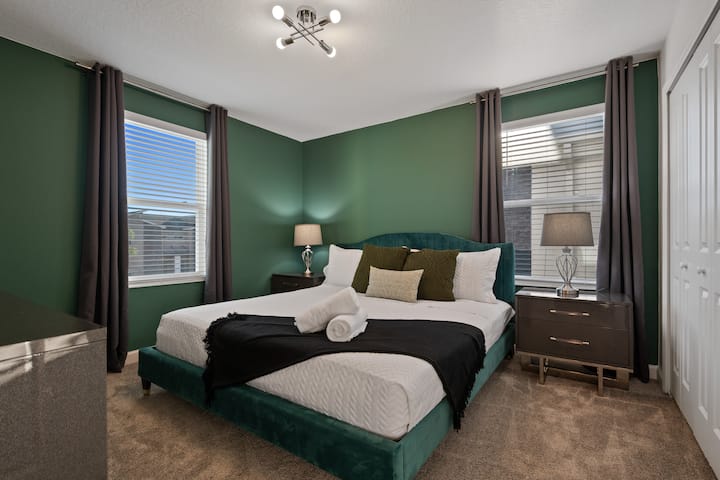 Udobna i elegantna spavaća soba savršena za opuštanje nakon zabavnog dana s obitelji i prijateljima, s mekanim krevetom i umirujućim zelenim tonovima za miran san.