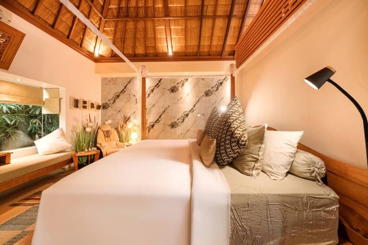 Every corner of the bedroom has been considered. The reading nook gives you a proper retreat when the pool has had its time — good light, deep cushions, and the kind of quiet that Seminyak doesn't usually offer at this price point.