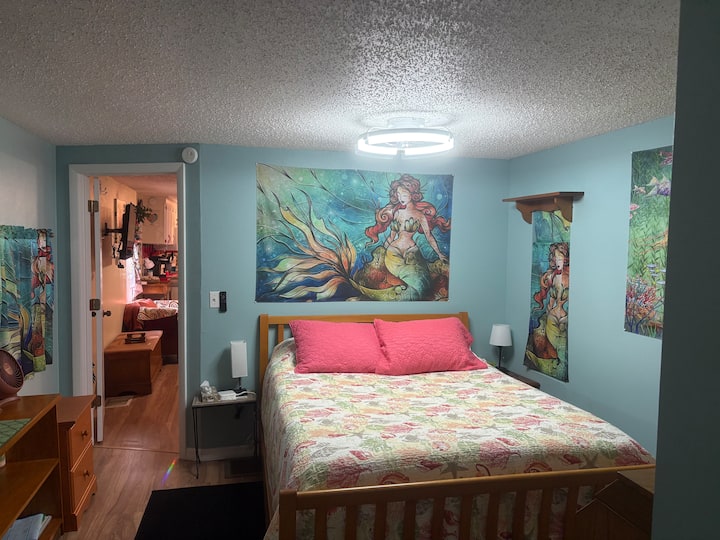 主卧配备标准双人床。 客厅/厨房的门打开了。 