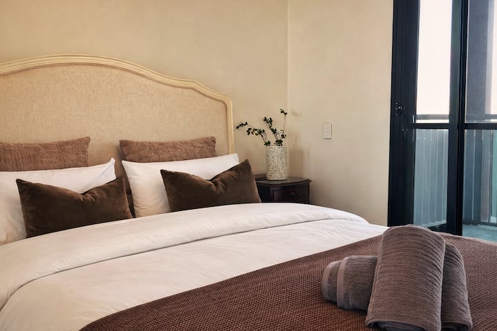 მთავარი საძინებელი საკუთარი სააბაზანოთი, საწოლით 152×203 სმ, პატიო‑აივნით, ქალაქის ცენტრისა და პარკის ხედებით