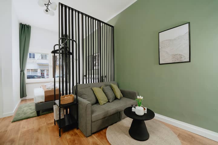 Woonkamer met slaapbank en scheidingswand