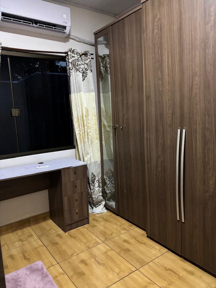 Spavaća soba s krevetom na kat, klima-uređajem i radnim stolom.