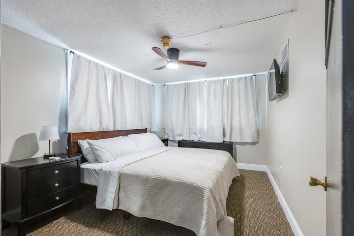 The Principles Office is secluded off of the kitchen area and boasts a king-size bed, bedside tables, plug-ins for devices, and a ceiling fan.