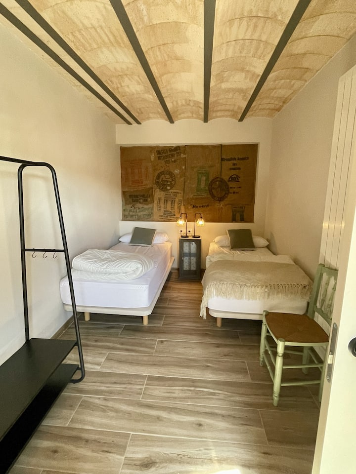 Esta habitación, con bóveda catalana y dos camas individuales, se encuentra en la primera planta, con un baño justo al lado. Como todas las habitaciones de la casa, cuenta con un ventanal y vistas al castillo. Videos en @Calmoreno_esplugacalba