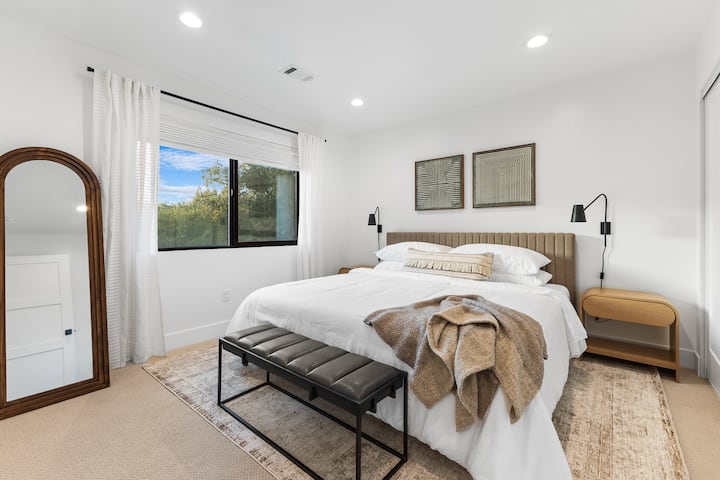 Experience serene comfort in this stylish bedroom featuring modern decor and stunning views, and blackout shades perfect for a relaxing getaway.