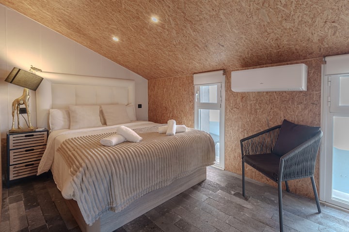 Dormitorio principal con cama doble y aire acondicionado.