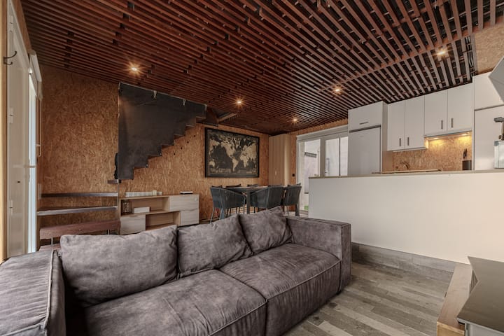Salón y comedor bajo el techo de lamas de madera.
