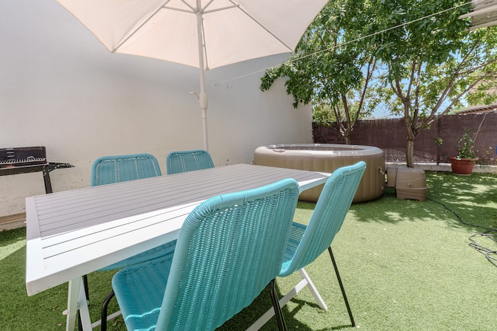 Jardín privado con comedor exterior y jacuzzi.