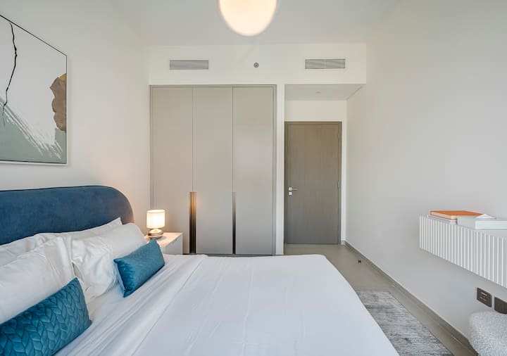 Dormitorio moderno: entra en un refugio elegante y relajante construido para la comodidad y la conveniencia. Lo más destacado es una lujosa cama tamaño king cubierta con sábanas blancas y almohadas suaves, que ofrece una noche de sueño de lujo.