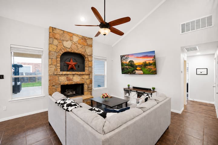 غرفة معيشة مشرقة بها مدفأة حجرية وسقف مقبب وأريكة مريحة مكونة من أقسام