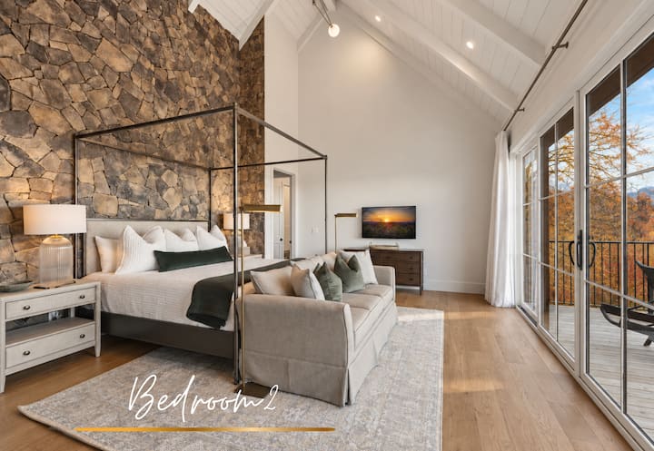 El dormitorio dos cuenta con una cama tamaño king contra una espectacular pared de roca, que combina el carácter de la montaña con una suave elegancia neutra.
